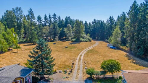 An aerial view of a home with a driveway and trees.