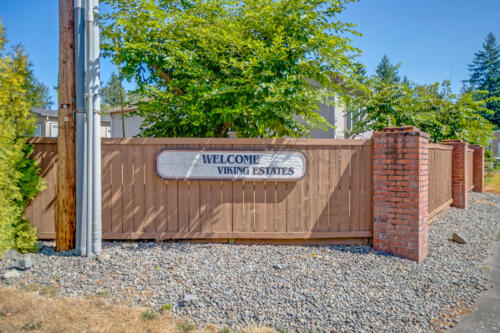 A sign with a welcome sign in front of a house.